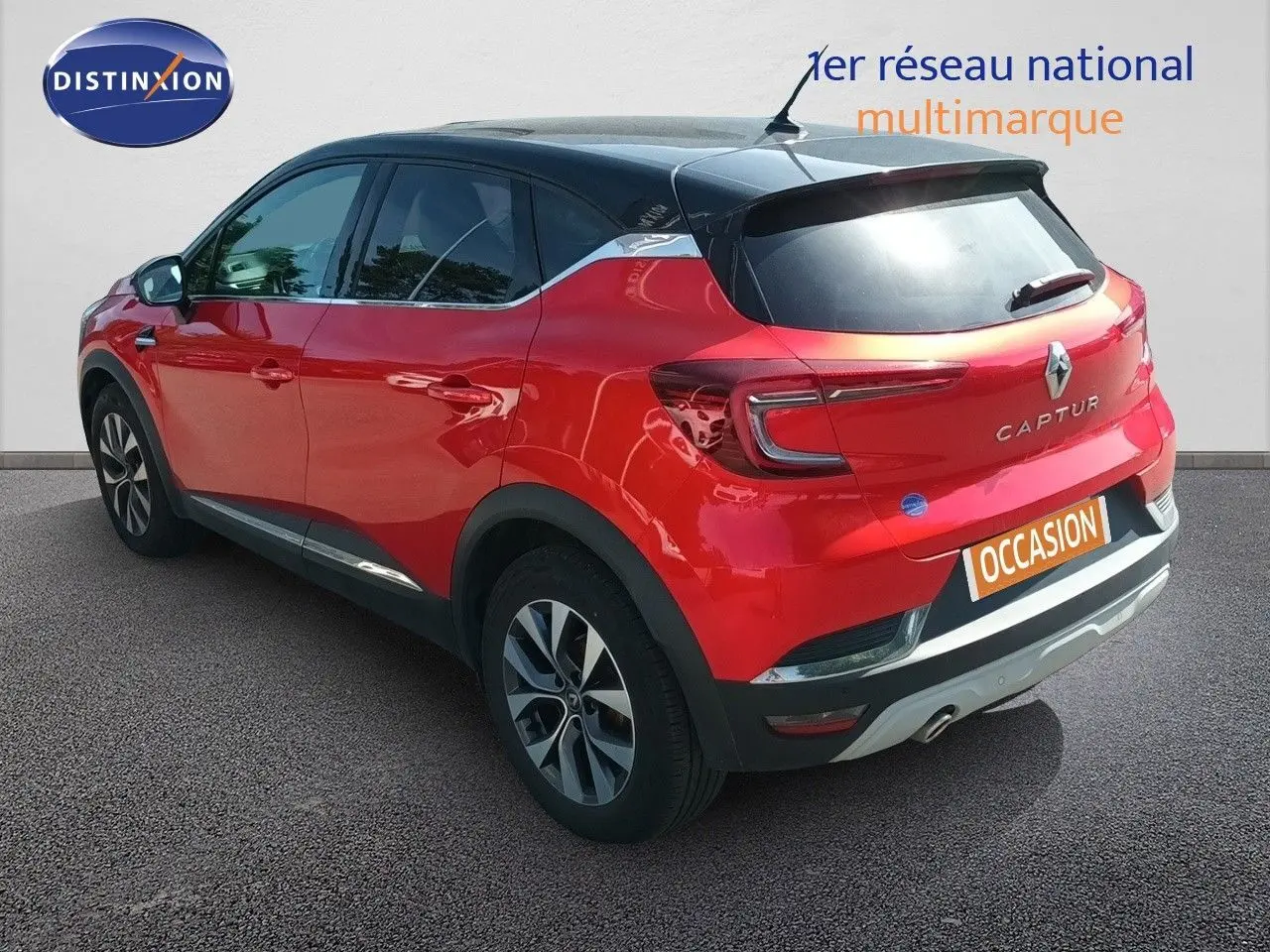Vue 3/4 arrière droite d'un Renault Captur TCE90 Intens rouge avec toit noir et jantes alliage biton.