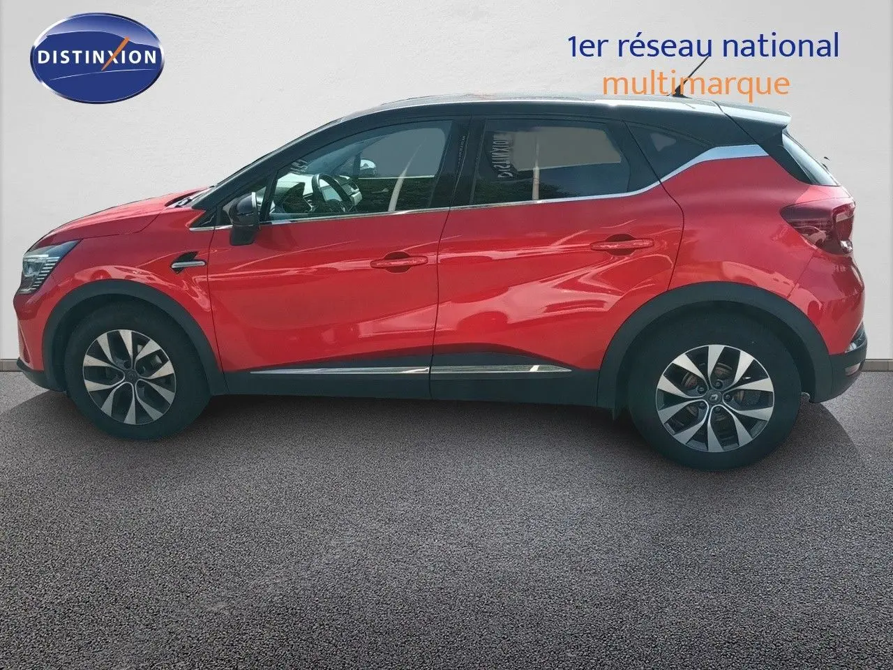 Profil droit d'un Renault Captur TCE90 Intens rouge avec toit noir, roues alliage et lignes modernes visibles.