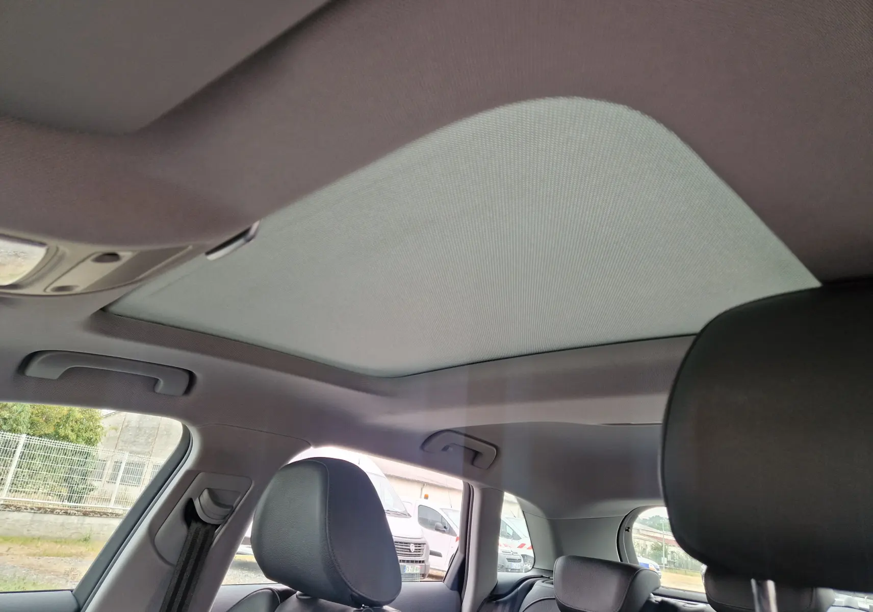 Toit ouvrant panoramique fermé vu de l'intérieur arrière de l'Audi A3 Sportback noir 2019, avec sièges en cuir.