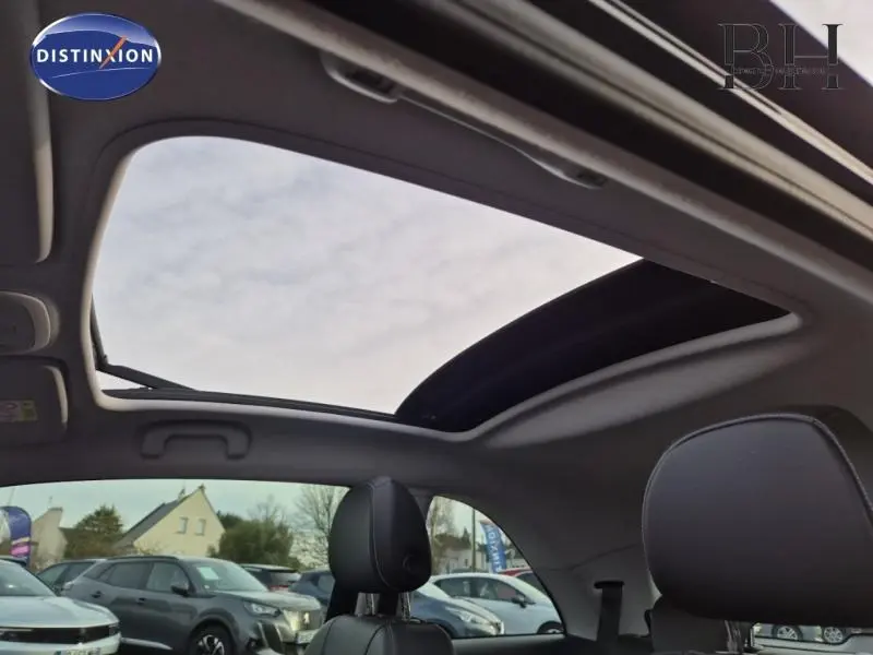Vue intérieure du toit ouvrant panoramique et des sièges en cuir noir de l’Opel Adam Rocks 2016, avec ciel visible.