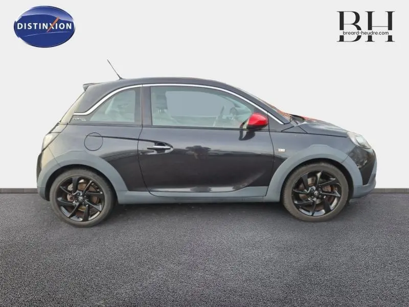 Vue de profil droit d'une Opel Adam Rocks noire avec rétroviseur rouge et jantes noires sur fond clair.