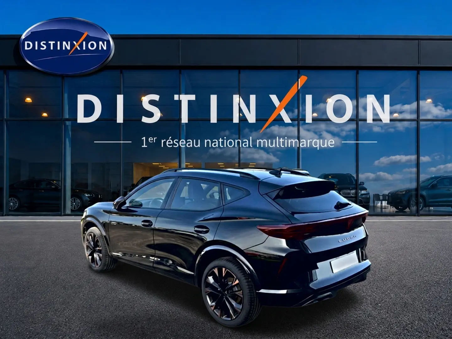 Vue 3/4 arrière droite d'un CUPRA Formentor noir brillant avec jantes 19 pouces devant une vitrine Distinxion.