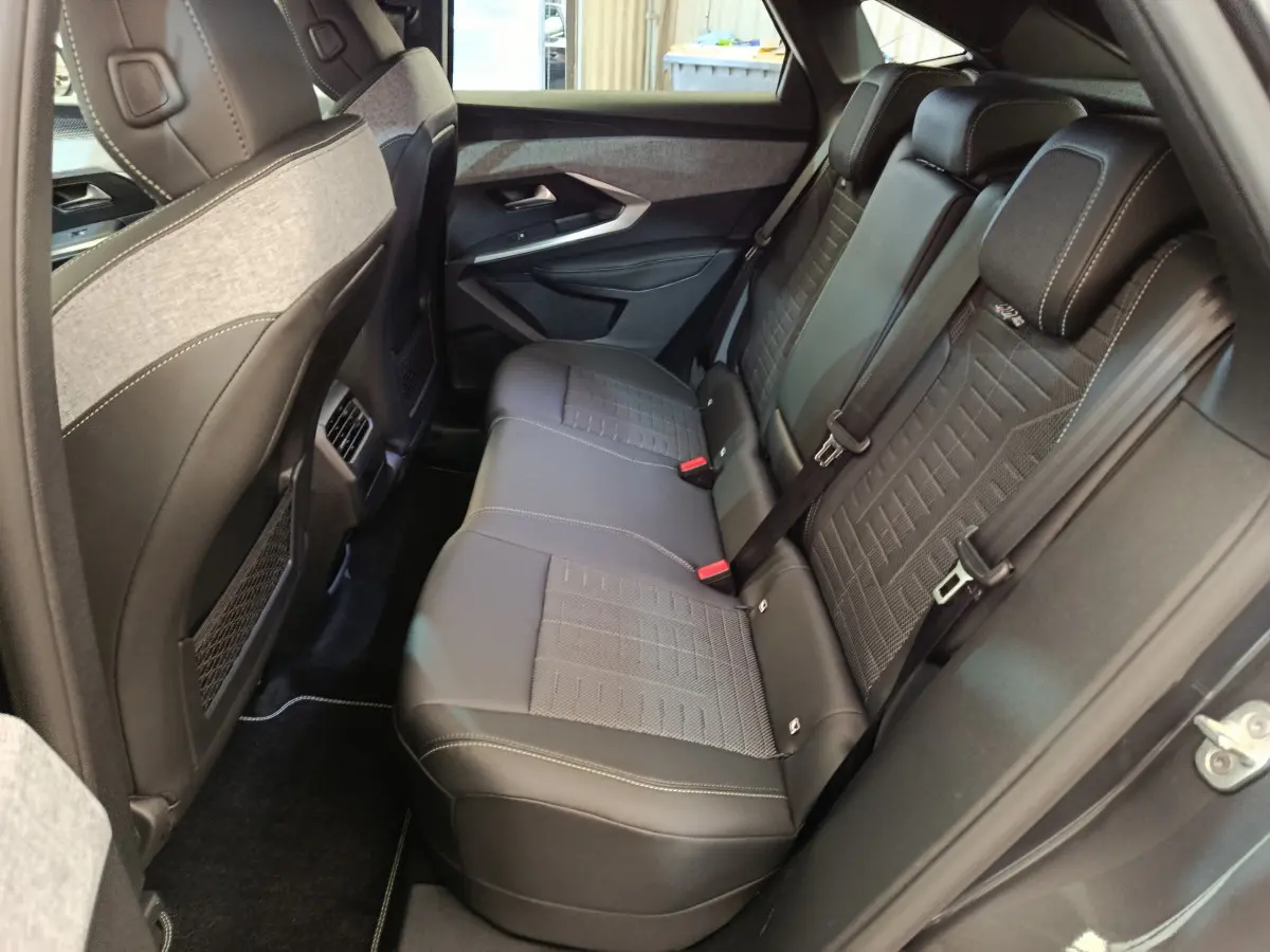 Vue intérieure côté droit montrant la banquette arrière en cuir noir et tissu gris du Peugeot 3008 1.2 Hybrid GT 2025.