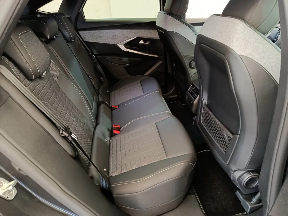 Vue intérieure côté gauche des sièges arrière en tissu et cuir gris du Peugeot 3008 1.2 Hybrid 145 GT noir.