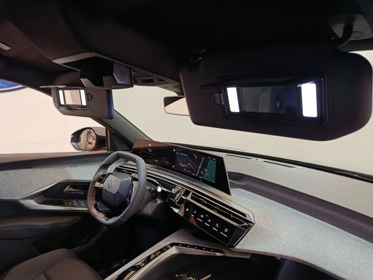 Vue intérieure du tableau de bord et volant cuir noir du Peugeot 3008 1.2 Hybrid 145 E-DCS6 GT avec écran tactile panoramique.