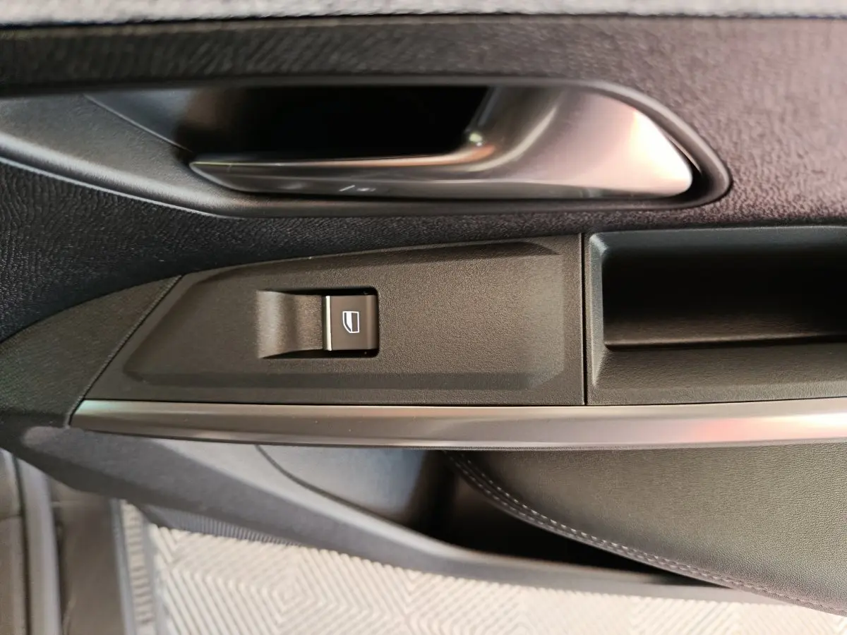 Détail de la commande de lève-vitre côté conducteur du Peugeot 3008 1.2 Hybrid 145 GT, intérieur noir.