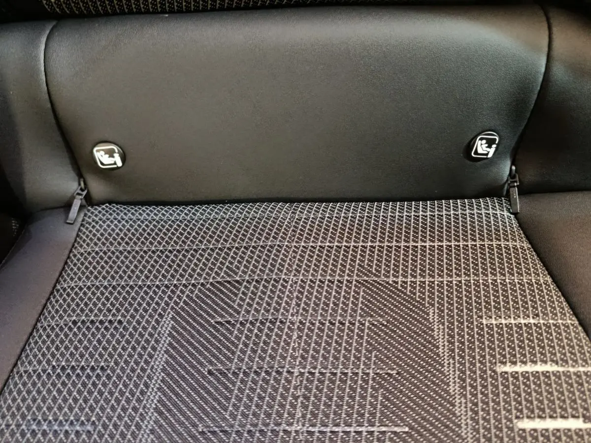Détail de la banquette arrière noire du Peugeot 3008 1.2 Hybrid 145 GT avec fixation Isofix visible.
