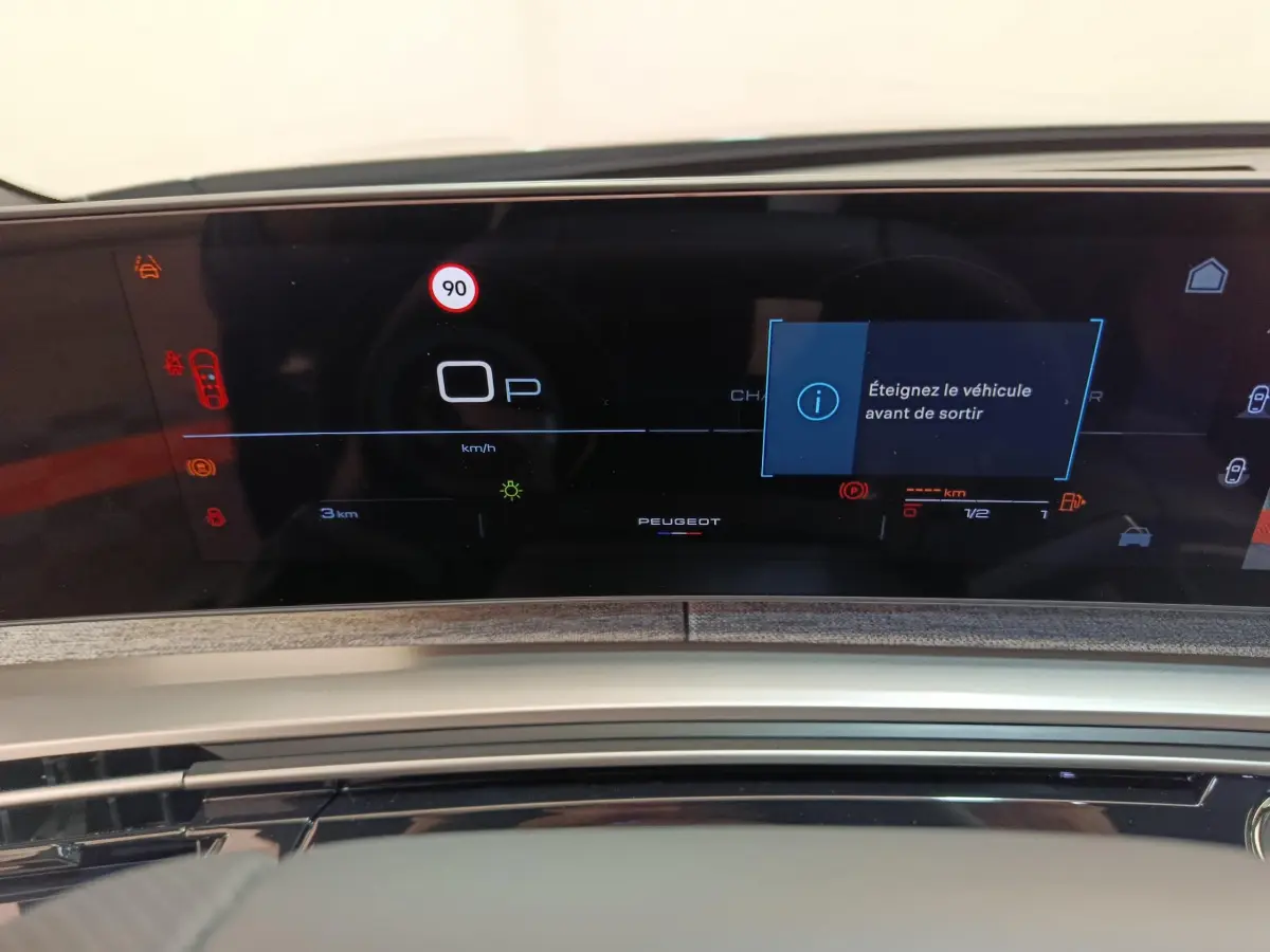 Tableau de bord numérique du Peugeot 3008 hybride 2025, affichage multifonctions avec alertes et logo central.