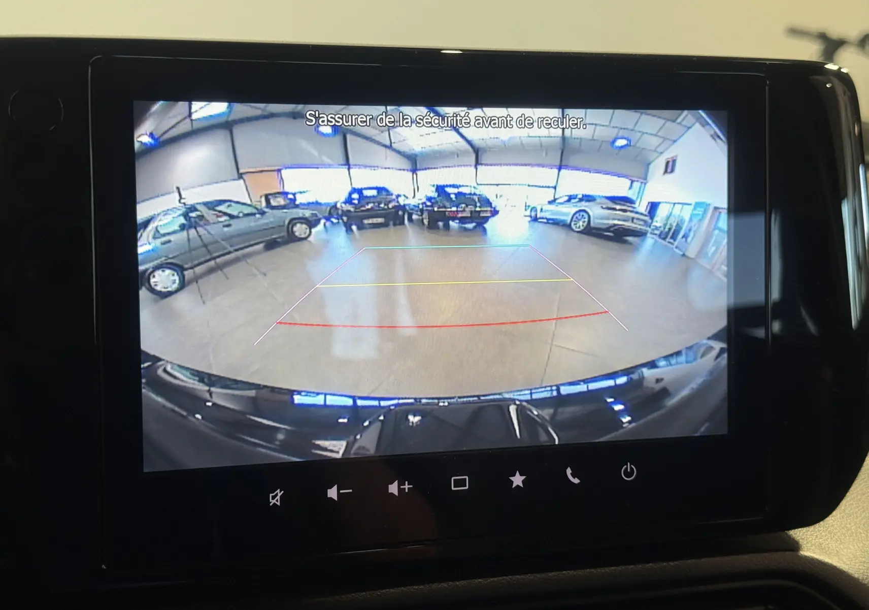 Vue arrière en caméra de recul de la Suzuki Swift 2025 noire, avec lignes de guidage et intérieur de garage visible.