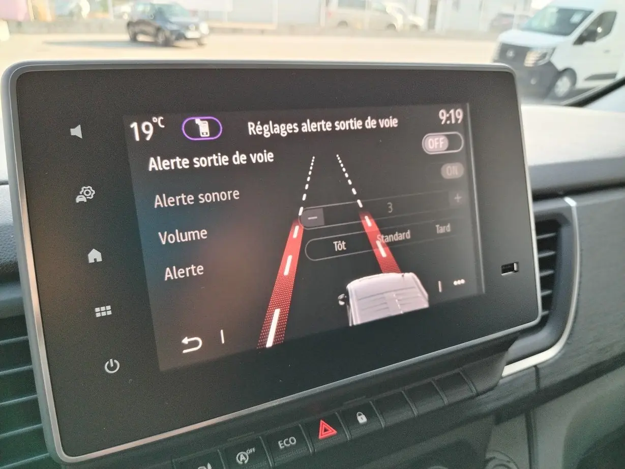 Écran tactile du tableau de bord du Nissan Primastar blanc 2025 montrant les réglages d'alerte de sortie de voie.