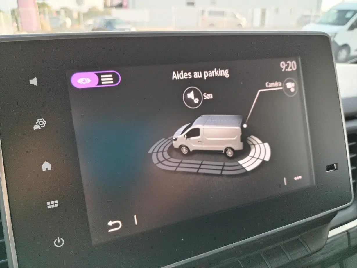 Écran intérieur affichant l'aide au parking avec une illustration du Nissan Primastar blanc vue de côté droit.