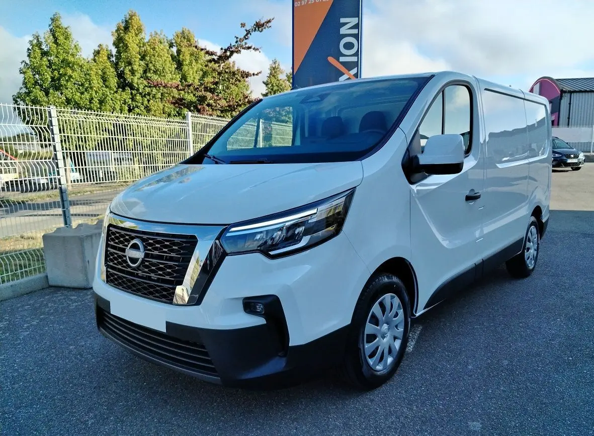 Vue 3/4 avant d'un utilitaire Nissan Primastar blanc 2025 avec calandre chromée et jantes acier.