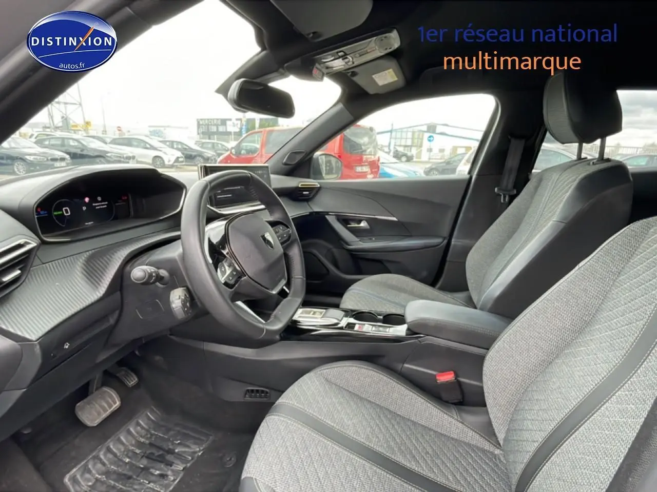 Vue intérieure côté conducteur du Peugeot 2008 E-136 allure 2025, sièges gris et tableau de bord moderne.