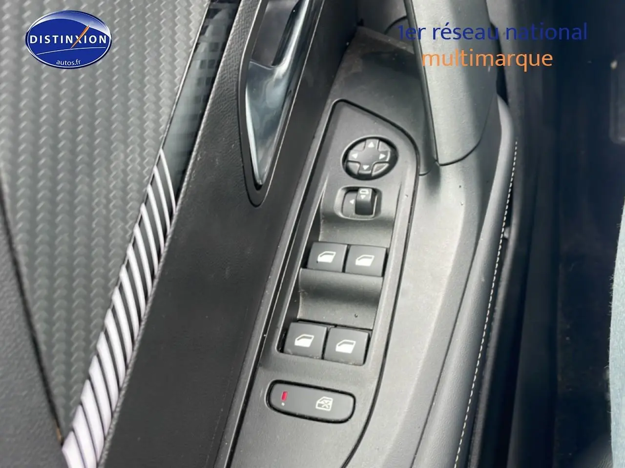 Détail de la commande des vitres électriques côté gauche dans l’habitacle du Peugeot 2008 gris sélénite.