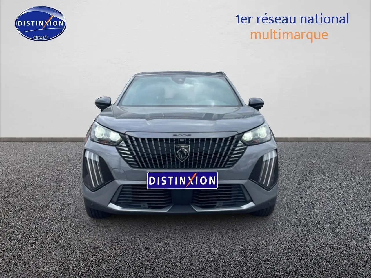 Vue avant du Peugeot 2008 E-136 allure gris sélénite avec calandre noire et feux LED allumés.