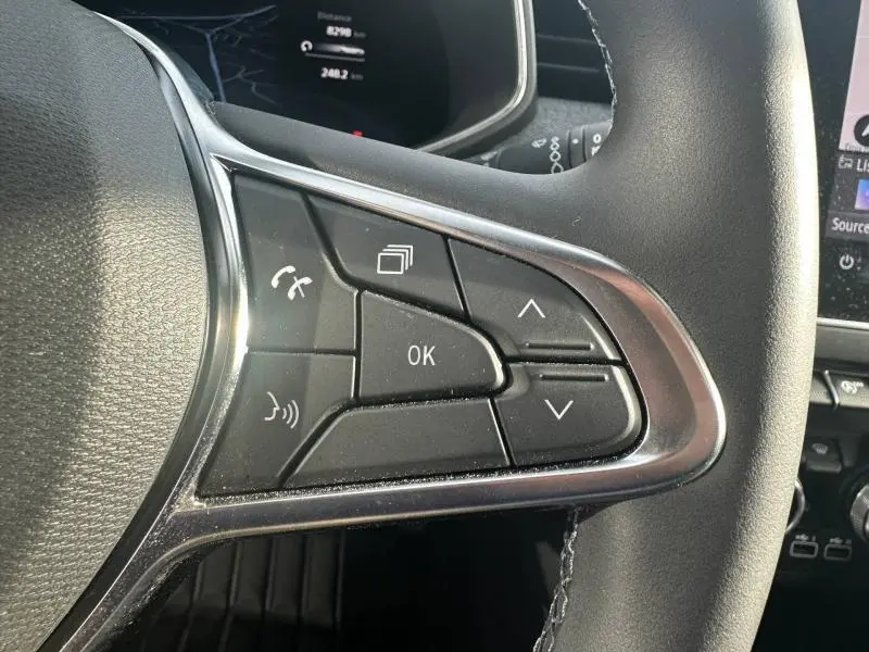 Gros plan sur les commandes multifonctions à droite du volant de la Renault Clio 2025, finition Techno, intérieur noir.