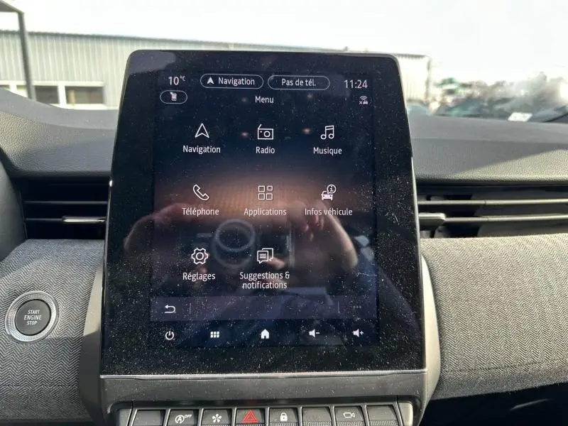 Écran tactile central de la Renault Clio 2025 affichant le menu principal avec options navigation, radio et téléphone.