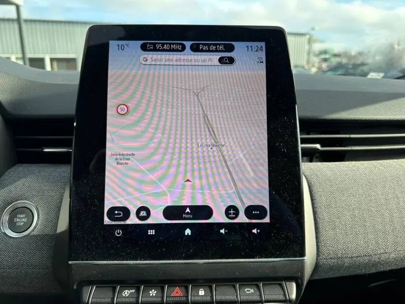 Écran tactile central du tableau de bord de la Renault Clio 2025 affichant la navigation GPS en plein jour.