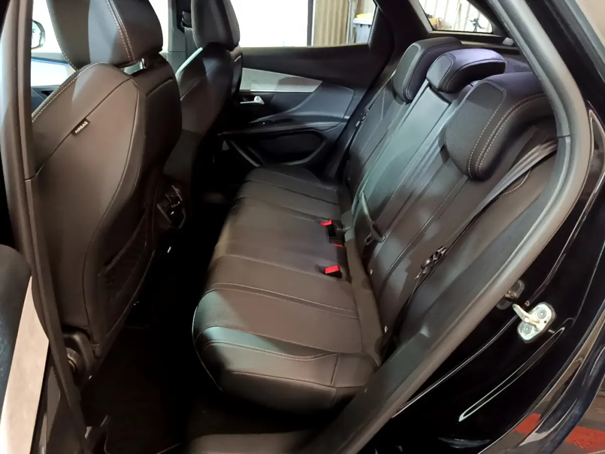 Vue intérieure côté droit des sièges arrière noirs en cuir du Peugeot 3008 GT 2023 avec surpiqûres contrastantes.