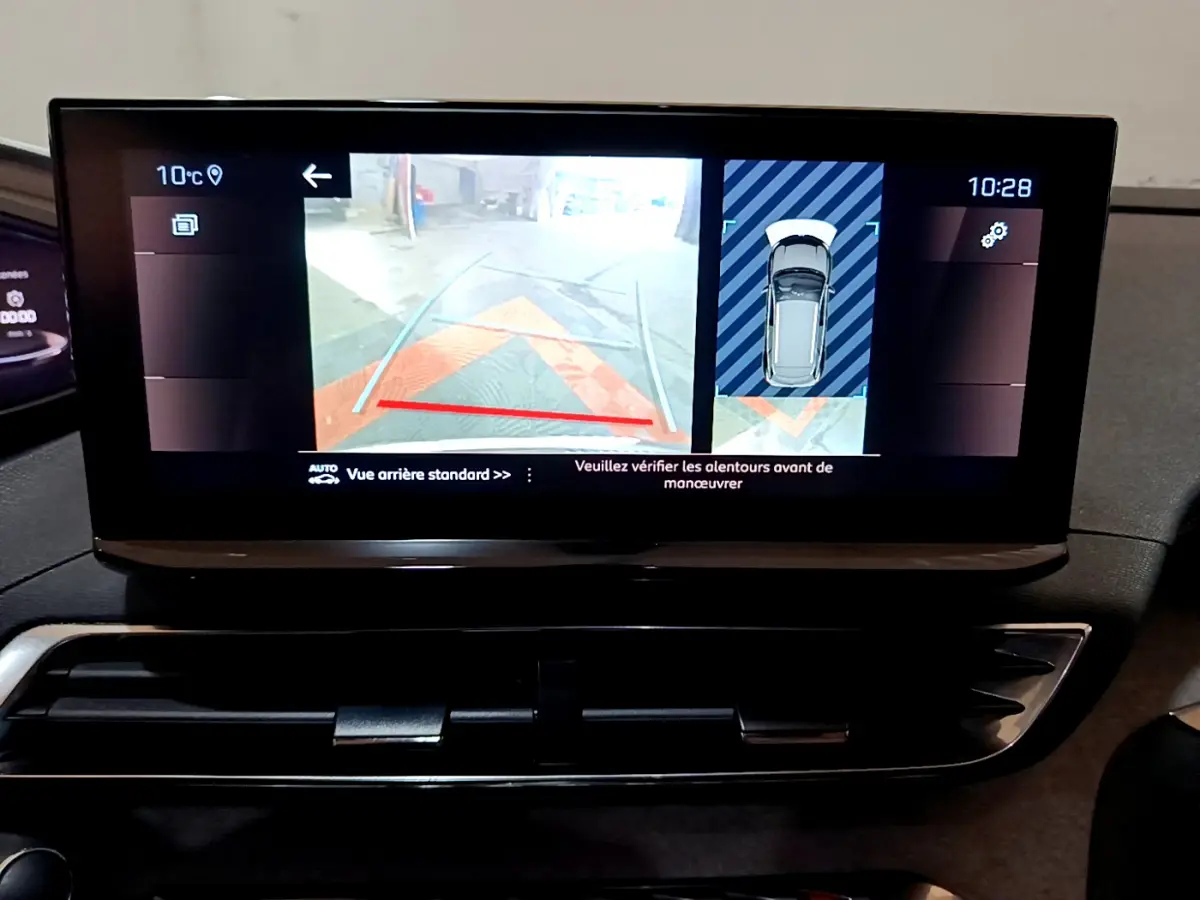 Écran tactile intérieur du Peugeot 3008 GT 2023 affichant la caméra de recul et l'aide au stationnement en vue arrière.