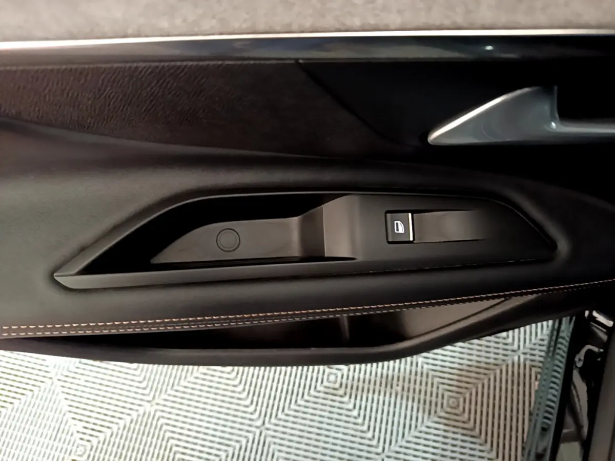 Gros plan sur la poignée intérieure et commande de verrouillage de la porte côté gauche du Peugeot 3008 noir 2023.