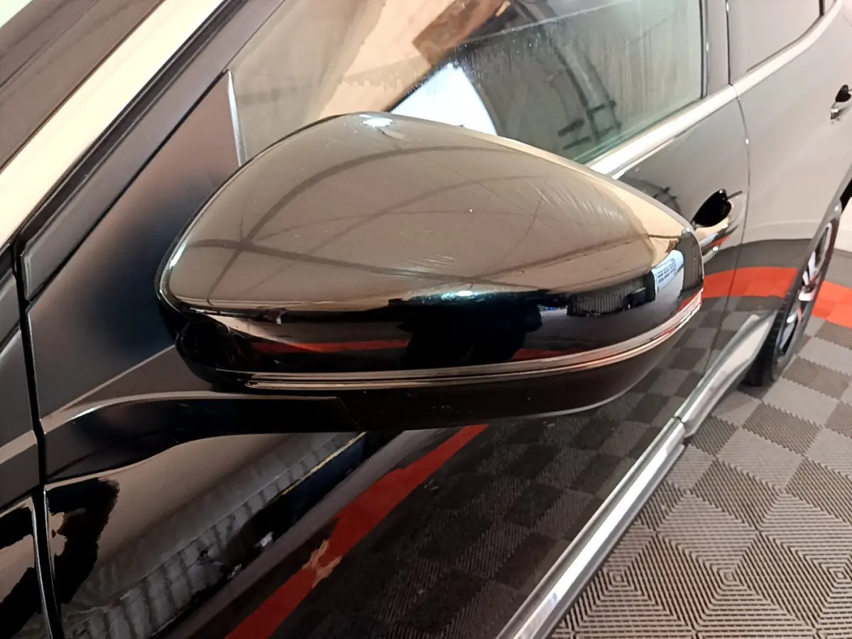 Rétroviseur côté gauche noir brillant du Peugeot 3008 2023 GT, avec reflet de l'environnement intérieur.