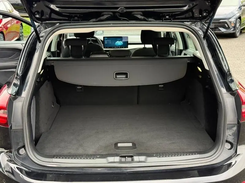 Coffre ouvert vu de l'arrière d'une Ford Focus SW 2023 noir Agate métallisé, avec cache-bagages et intérieur spacieux.