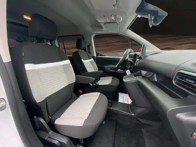 Vue intérieure côté conducteur du Citroën Berlingo blanc 2025, montrant sièges bi-ton, volant cuir et tableau de bord moderne.