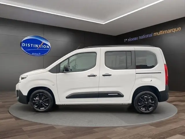 Vue latérale droite d'un Citroën Berlingo blanc 2025 avec jantes noires et protections latérales noires.