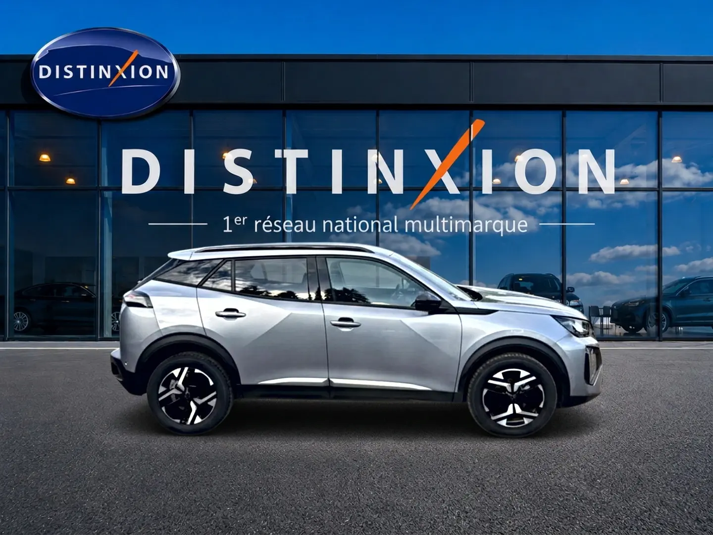 Peugeot 2008 gris artense vue de profil côté gauche devant une vitrine avec logo Distinxion.