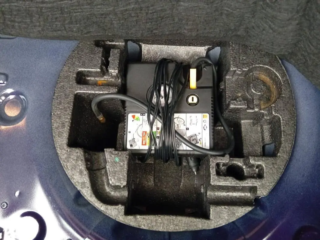 Chargeur et câbles rangés dans le coffre, vue plongeante sur l’espace de rangement en mousse violet de la Renault ZOE électrique 2022.