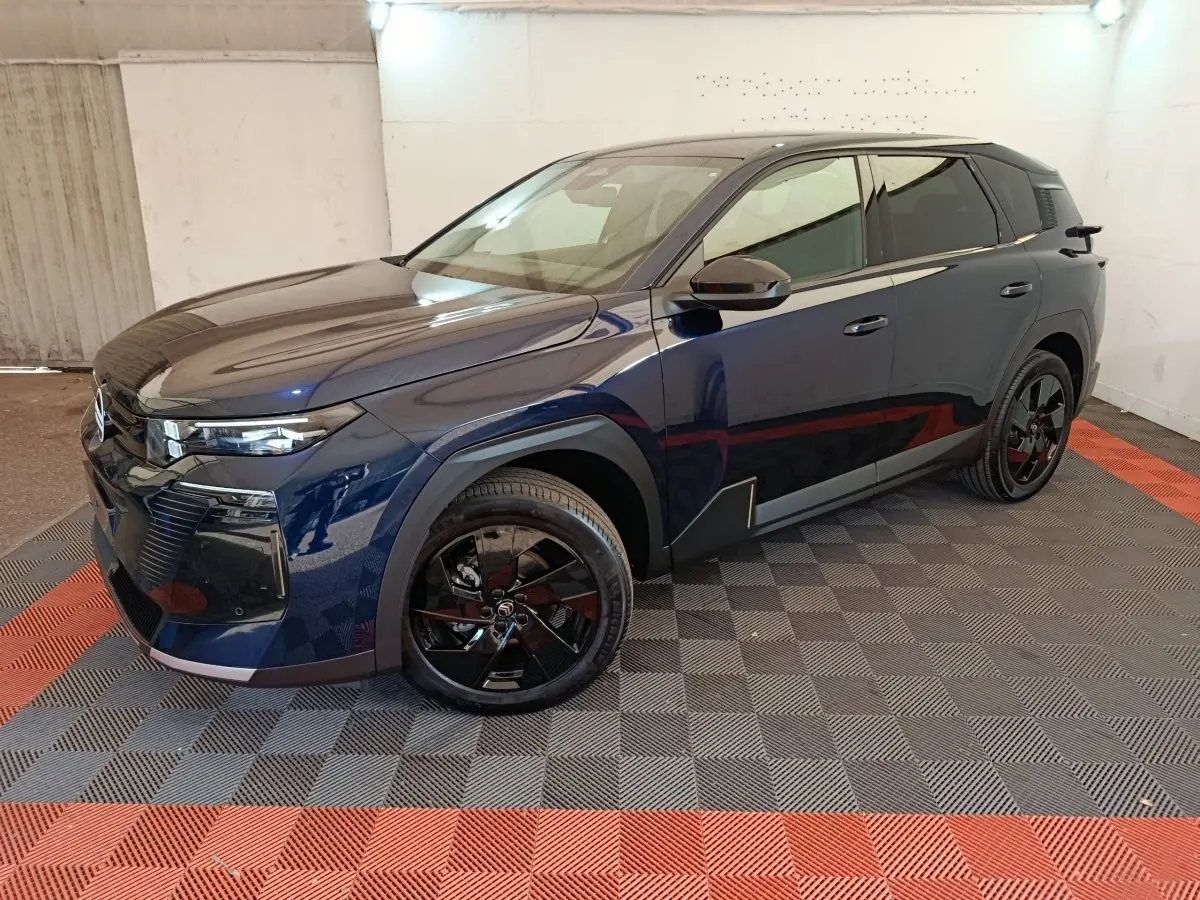 Citroën C5 Hybride bleu en 3/4 avant droit, avec jantes noires brillantes et lignes anguleuses modernes.
