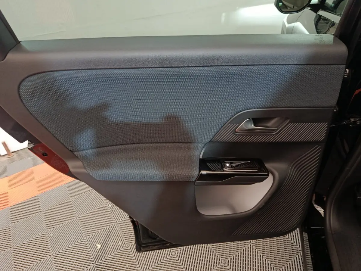 Vue intérieure de la porte arrière droite noire avec poignée argentée et commande de fenêtre sur Citroën C5 Hybride 2026.