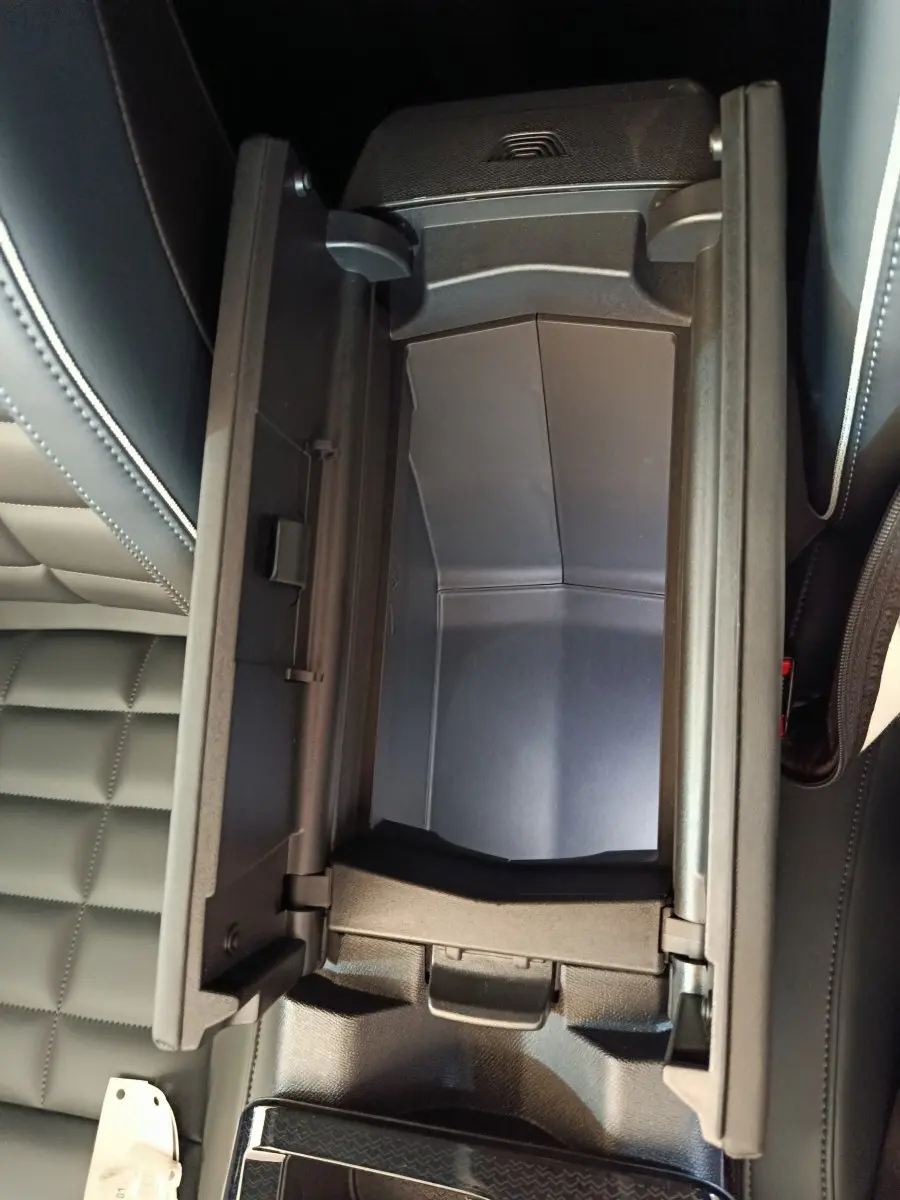 Vue rapprochée de la console centrale ouverte avec rangement intérieur noir dans un Citroën C5 Hybride 2026.