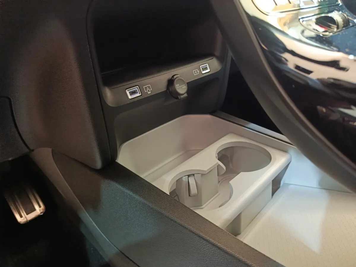 Gros plan sur la console centrale de la Citroën C5 Hybride 2026, montrant les ports USB et prise 12V, avec porte-gobelets gris.