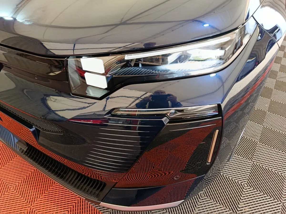 Gros plan sur l’avant droit bleu d’une Citroën C5 Hybride 2026 avec phares LED et détails de calandre moderne.