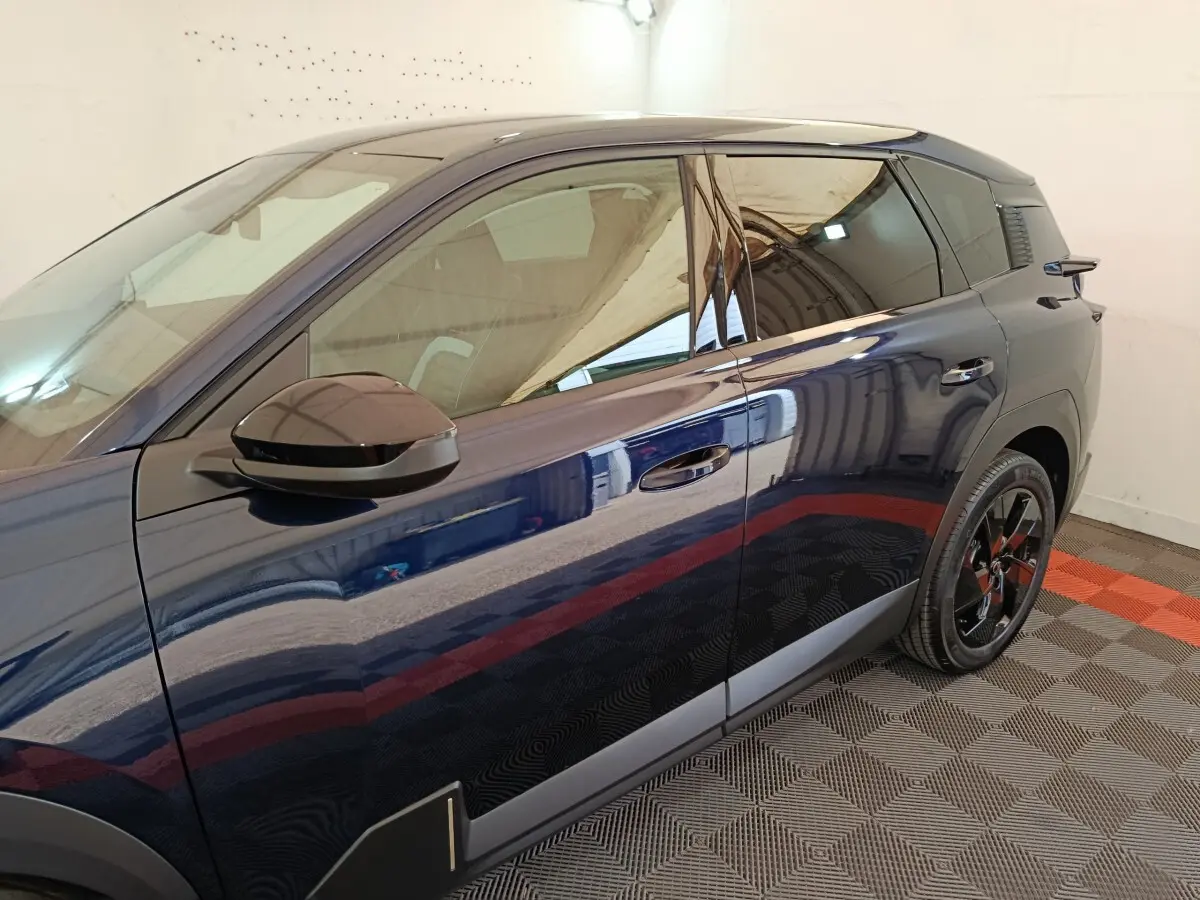 Vue latérale gauche d'une Citroën C5 hybride bleu foncé avec rétroviseur noir et jantes noires brillantes.