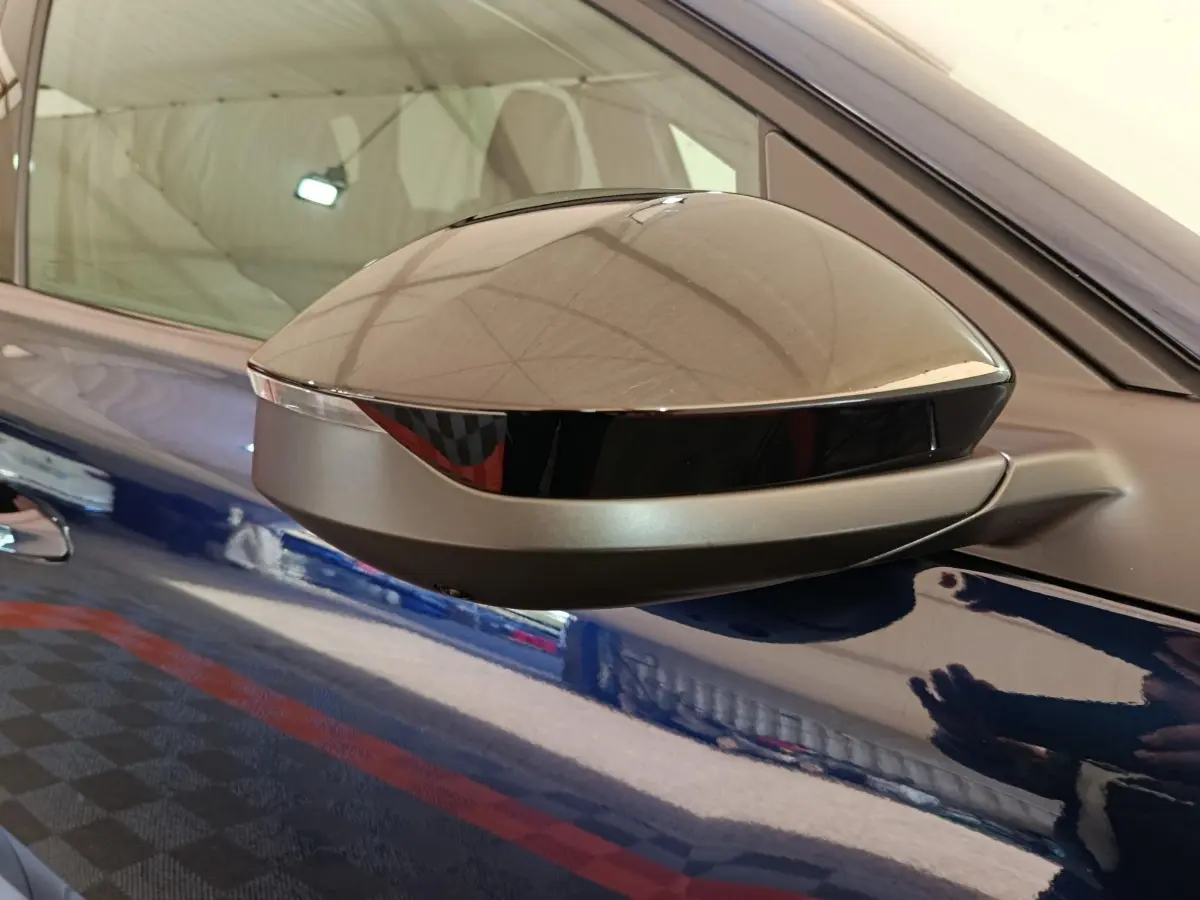 Gros plan sur le rétroviseur côté droit gris métallisé d'une Citroën C5 hybride bleu brillant, reflet intérieur visible.