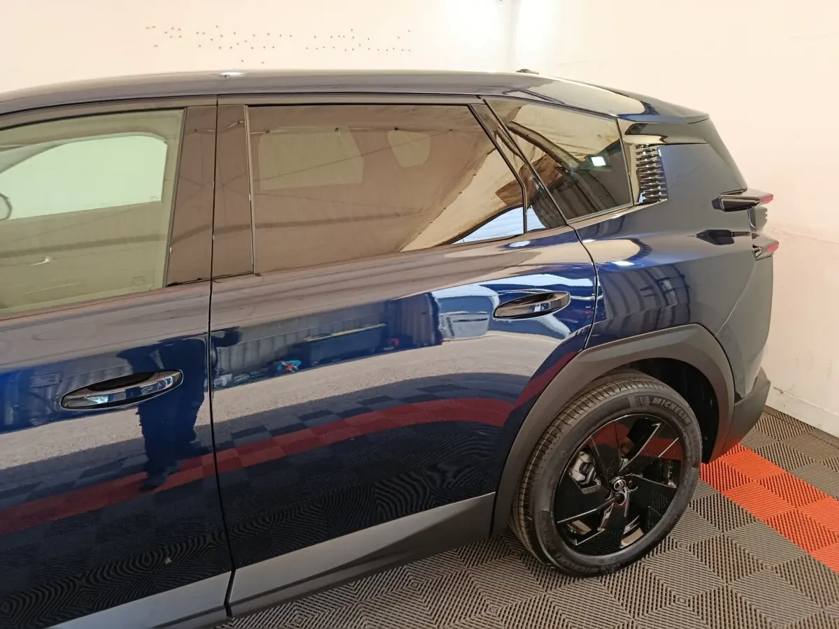 Vue latérale droite d'une Citroën C5 hybride bleu foncé avec jante noire et vitres teintées.