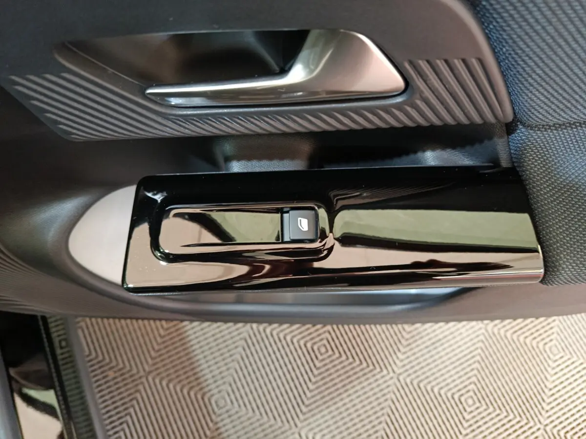 Gros plan sur la commande de lève-vitre noir brillant côté porte intérieure d'une Citroën C5 Hybride 2026.