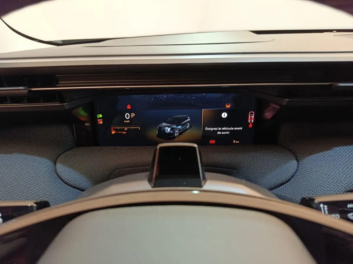 Vue rapprochée du combiné d'instruments numérique de la Citroën C5 Hybride 2026 avec affichage multifonctions et alertes visibles.