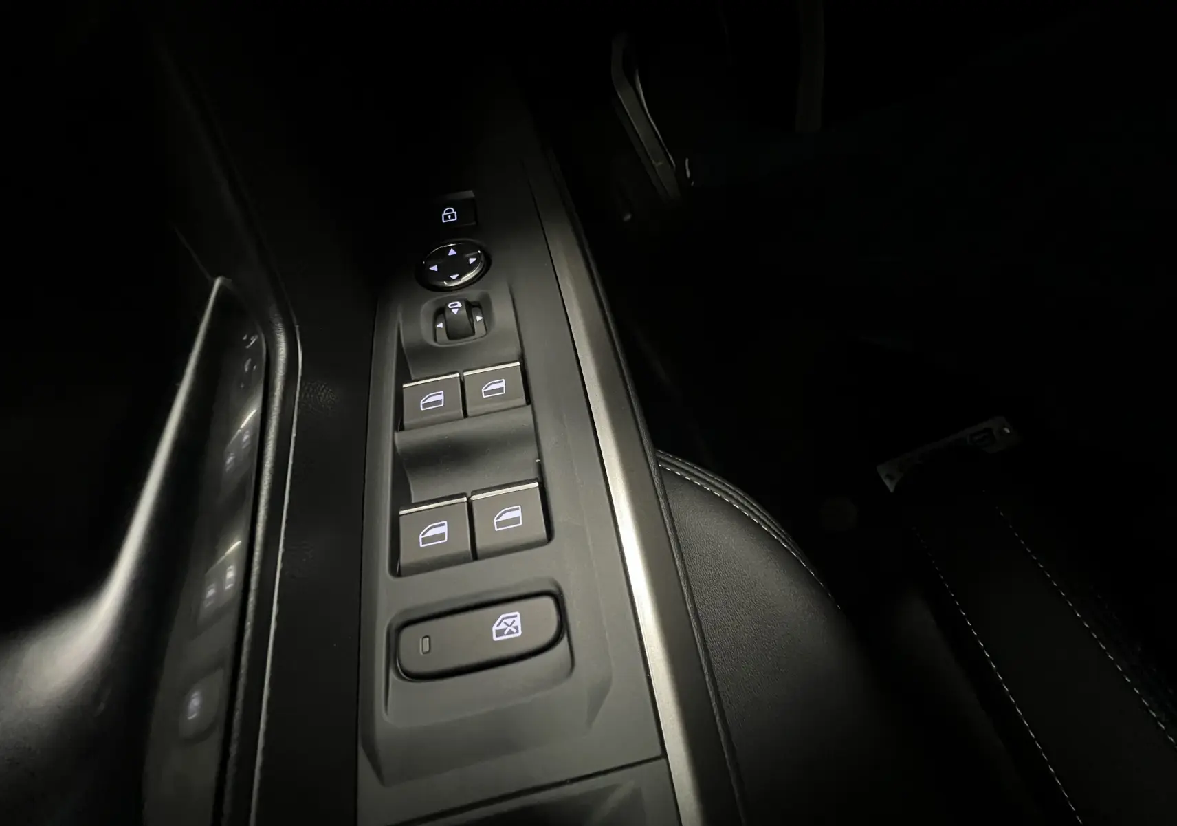 Commandes des vitres et rétroviseurs côté gauche du Peugeot 5008 noir, éclairage intérieur discret.