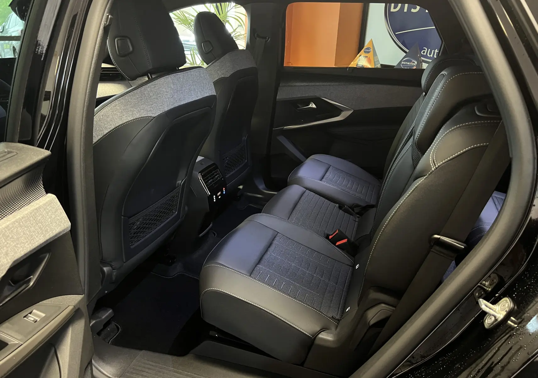 Vue intérieure côté droit des sièges arrière en cuir noir et tissu gris du Peugeot 5008 NV Hybrid 136 E-DCS6 GT noir 2025.