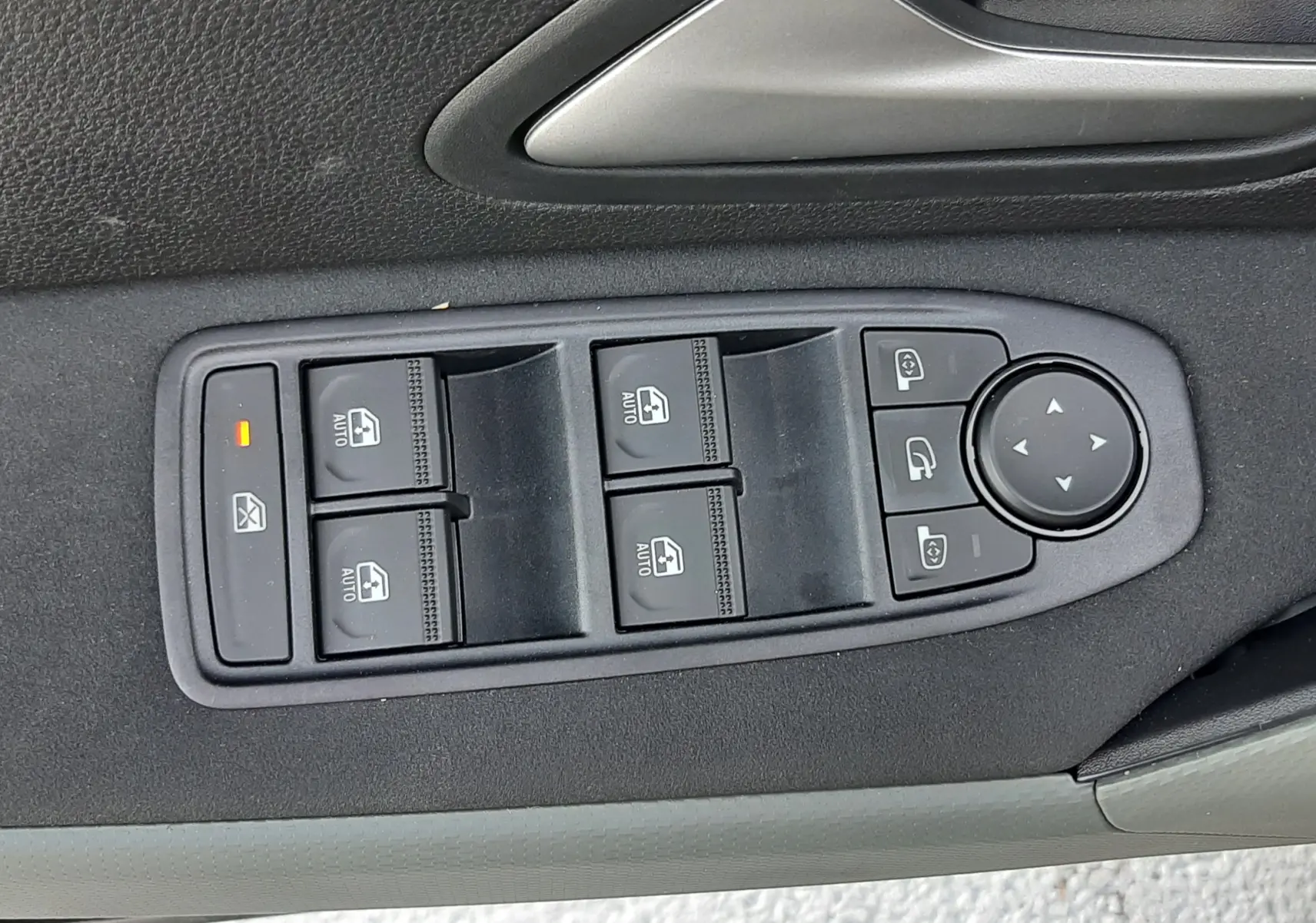 Panneau de commandes des vitres et rétroviseurs côté conducteur du Dacia Duster 1.6 Hybrid 2025, intérieur gris.