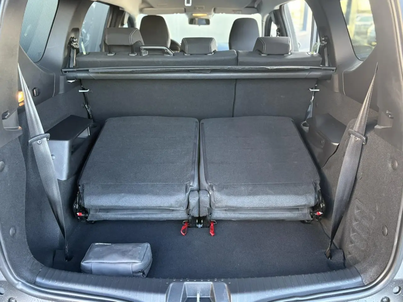 Vue arrière du coffre du Dacia Jogger gris Schiste 2025 avec sièges rabattus et espace de chargement dégagé.
