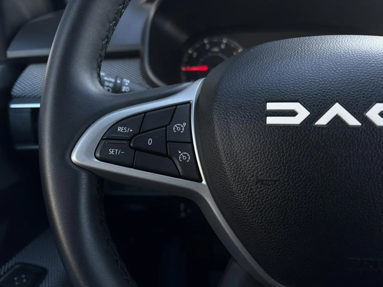 Gros plan sur le volant noir du Dacia Jogger 2025 avec commandes de régulateur de vitesse à gauche.