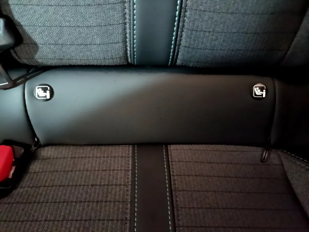 Gros plan sur la banquette arrière grise de la Peugeot 208 avec logos Isofix visibles de chaque côté.