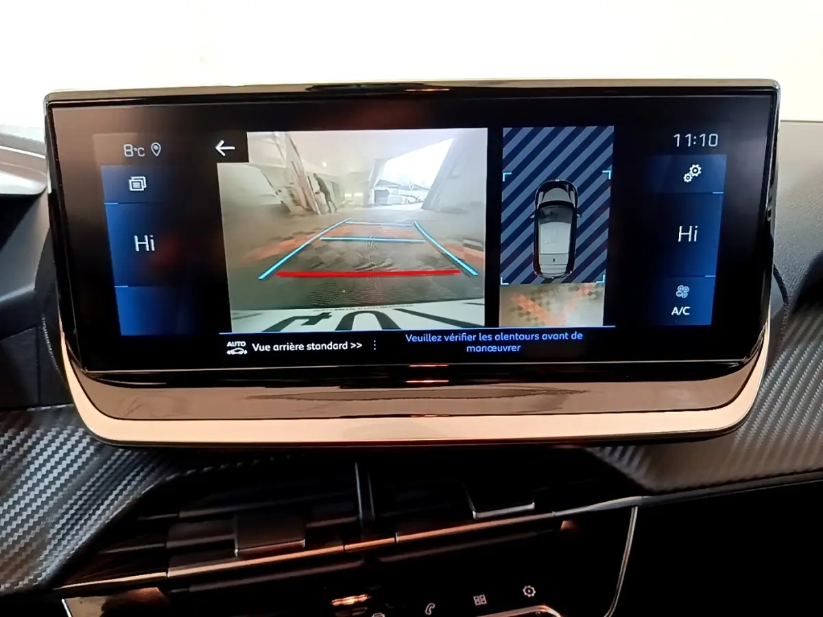 Écran tactile central de la Peugeot 208 affichant la caméra de recul et l’aide au stationnement arrière.