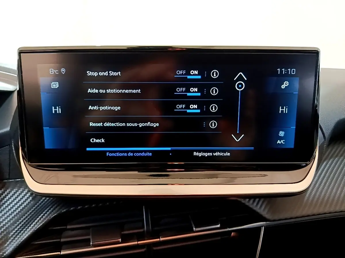 Écran tactile central de la Peugeot 208 jaune, affichant les réglages d’aide à la conduite et climatisation.