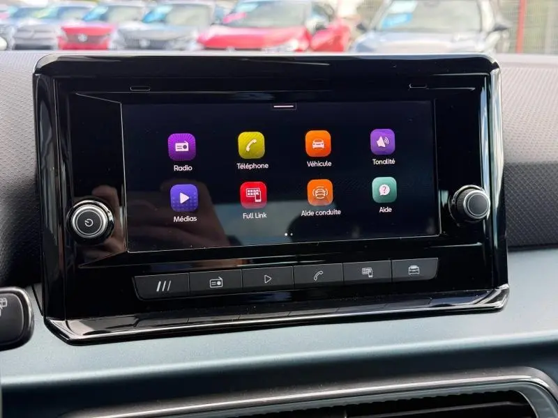 Vue rapprochée de l'écran tactile central du tableau de bord du SEAT Arona 2025 avec interface multimédia colorée.